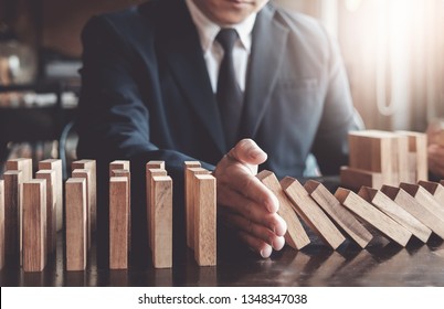 Business risk control concept, Businessman protect wooden block fall to planning and strategy in risk to business Alternative and prevent. Investment Insurance Business.