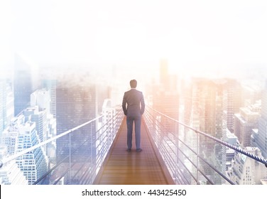 Business risk and research concept with back view of businessman standing on suspended bridge above New York city and looking into the distance. Toned image, 3D Rendering