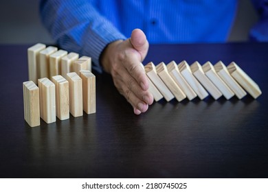 Business Risks and Strategies hand stop falling wooden block domino Consequences of falling blocks defense and development for security Prevention and problem solving concepts - Shutterstock ID 2180745025