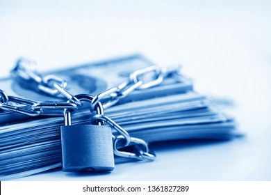 Business safety or financial protection or restriction access. Heap of money in chain with padlock isolated on white