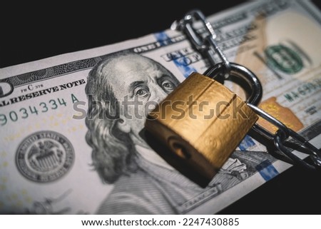Business safety or financial protection or restriction access. Heap of money in chain with padlock on black. the concept of keeping or banning cash dollars. money is banned.
