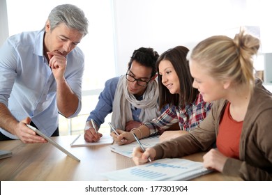 Business School Students In Marketing Class With Teacher