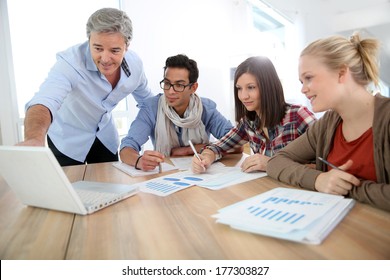 Business School Students In Marketing Class With Teacher