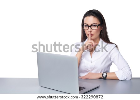 Business secret concept. Business woman working on a laptop making hush sign, isolated over white