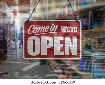 A Business Sign That Says 'Come In We're Open' On A Book Store Window.