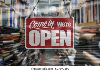 A Business Sign That Says 'Come In We're Open' On A Book Store Window.