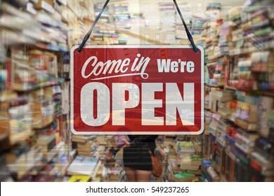 A Business Sign That Says 'Come In We're Open' On A Book Store Window.