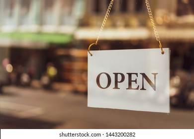A business sign that says ‘Open’ on cafe or restaurant hang on door at entrance. Vintage color tone style. - Shutterstock ID 1443200282
