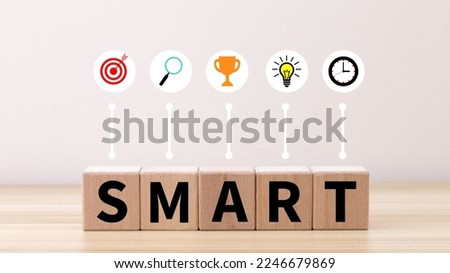 Business and SMART symbol. Wooden blocks with words 'SMART, specific measurable achievable realistic timely'. Yellow background, copy space. Business and SMART concept.