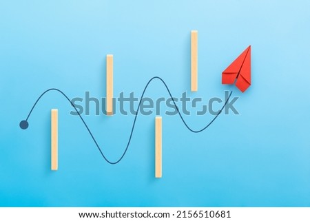 Business for solution and overcoming barriers concept with red paper plane, blue background