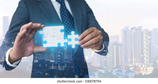 Business solutions, success and strategy concept. Businessman hand connecting jigsaw puzzle. Double exposure and background down opacity. - Shutterstock ID 530078794