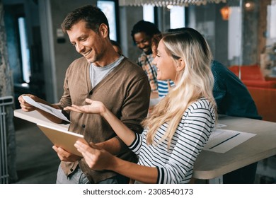 Business solutions, technology and strategy concept. Colleagues working and brainstorming in office - Powered by Shutterstock