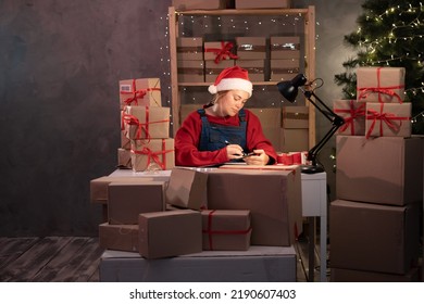 Business Start Up SME Concept. Young Woman Startup Entrepreneur Small Business Owner Working At Home At Night, Packaging And Delivery Situation. Christmas Sale Season.