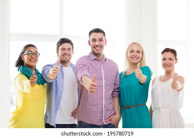 Business, Startup And Office Concept - Happy Creative Team Showing Thumbs Up In Office