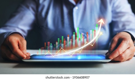 Business strategy development and growing growth plan. Businesswoman holding tablet with  growing virtual hologram of statistics, graph and chart.
