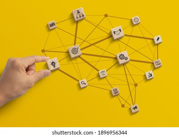 Business strategy, business management or business success concept. Hand is arranging wooden blocks with business icon in low polygon brain shape network on yellow background.