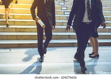 Business Street In Big City.After Office Work Corporate Building Businessman Walking Quick Steps Some Person Hold Business Briefcase Go Down From Stairs. Some Person Commute Go Home By Car Or Walk .