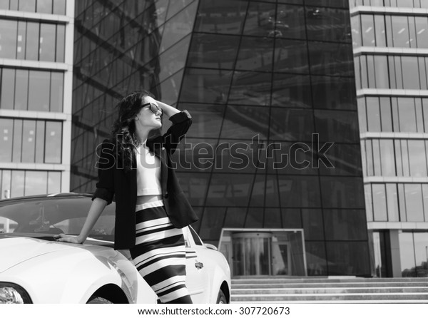 Business stylish woman near sport car black and\
white shot