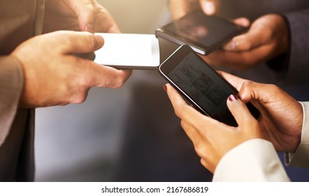 Business Success Is All About Making Connections. Shot Of Coworkers Using Their Digital Devices In Synchronicity.