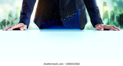 Business Success Concept. Professional Businessman With High Profit Graph On Digital Tablet. Double Exposure Image Of Urban Building As Background