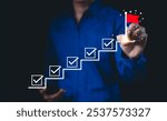 Business success and goal achievement steps. Businessman drawing checkmarks on virtual staircase steps toward achieving goals, ending with red flag as success marker. Planning, progress, goal setting,