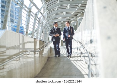 Business Taliking.Two Smiling Young Businessmen In Elegant Business Suits, Walking And Talking In City Street.