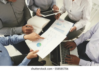 Business team analyzing and discussing charts, view from above - Shutterstock ID 558585706