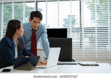 Business team analyzing documents, graphs, and data with a laptop, tablet, and smartphone. Collaboration, strategy, and success.
