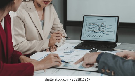 Business team analyzing financial charts and graphs on digital tablet and reports during a meeting in a modern office - Powered by Shutterstock