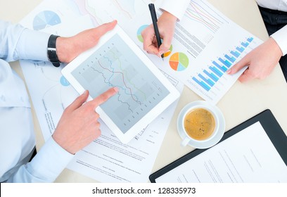 Business team analyzing income charts and graphs with modern digital tablet. Top view photo shoot. - Powered by Shutterstock