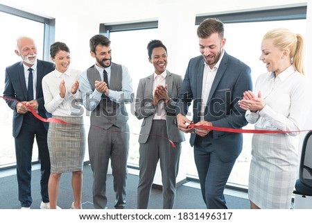 Business team applauds on cutting of red ribbon and grand opening