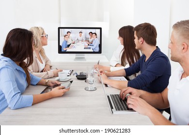 Business Team Attending Video Conference At Desk In Office