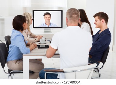 Business Team Attending Video Conference At Desk In Office