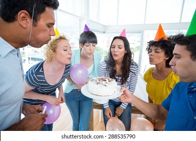 Business Team Blowing Candles On A Birthday Cake In The Office