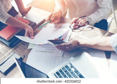 Business team brainstorming. Marketing plan researching. Paperwork on the table, laptop and mobile phone - Shutterstock ID 425326012