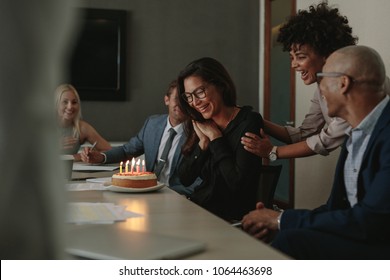 Business Team Celebrating Female Colleague's Birthday With Cake In Office. Birthday Celebration Of A Female Associate During A Staff Meeting.