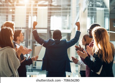 Business team celebrating a triumph with arms up - Shutterstock ID 708636280