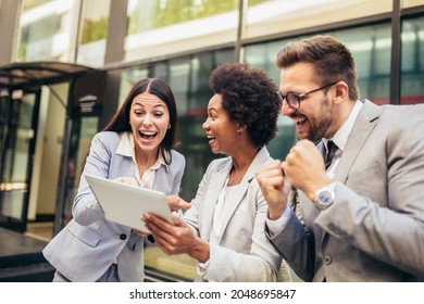 Business Team Celebrating A Triumph, Looking At Digital Tablet.