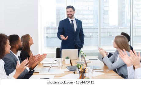 Business team congratulating successful male manager with applause after meeting