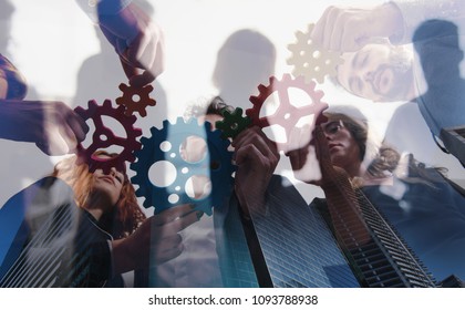 Business Team Connect Pieces Of Gears. Teamwork, Partnership And Integration Concept. Double Exposure