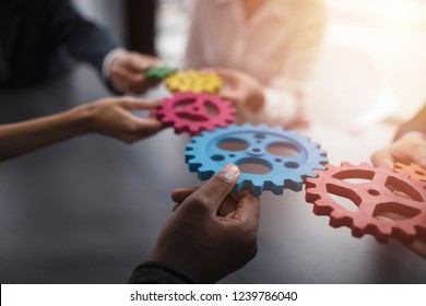 Business team connect pieces of gears. Teamwork, partnership and integration concept - Shutterstock ID 1239786040