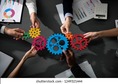 Business team connect pieces of gears. Teamwork, partnership and integration concept