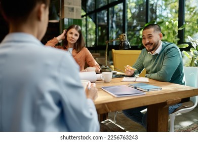 Business team discussing startup project ideas on meeting in coworking space - Powered by Shutterstock