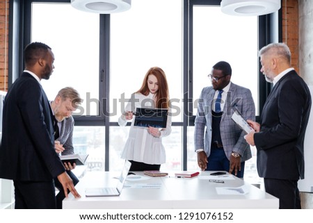Business team of ethnic people working in the office standing at the table brainstorming