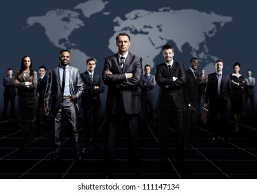 Business Team Formed Of Young Businessmen Standing Over A Dark Background