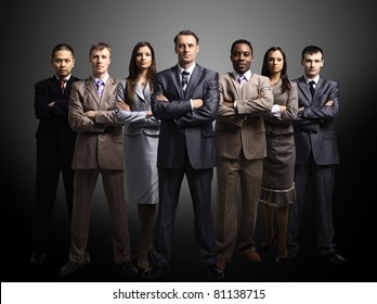 business team formed of young businessmen standing over a dark background
