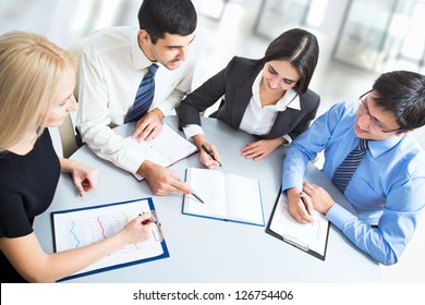 A business team of four plan work in office