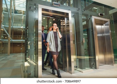 Business team going on elevator and talking - Powered by Shutterstock