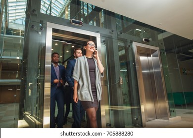 Business team group exit on elevator. Business people in a large glass elevator in a modern office - Powered by Shutterstock