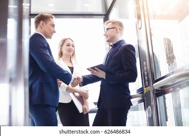 Business team group going on elevator. Business people in a large glass elevator in a modern office - Powered by Shutterstock - Get 15% off with code: PIKWIZARD15